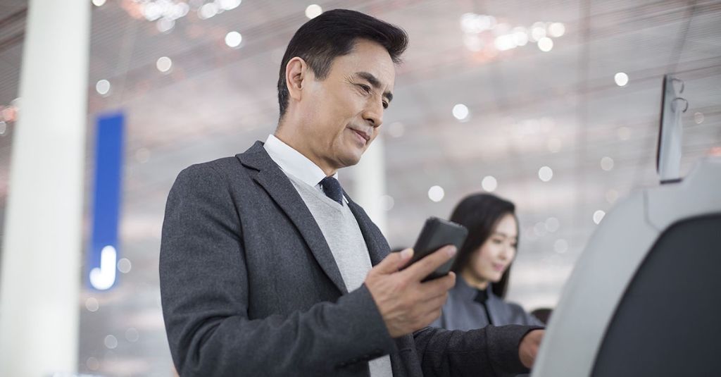 Man with a smartphone at an airport.
