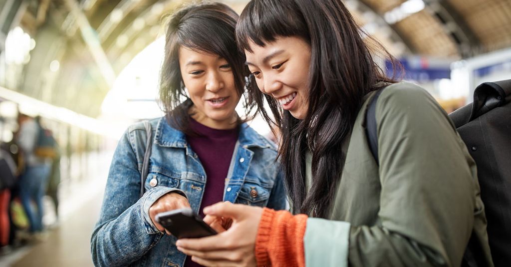 Two women looking at something on a smartphone.